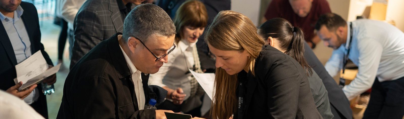 Delegates gathered around the materials table in the foyer of an Excellence in Digital Banking summit
